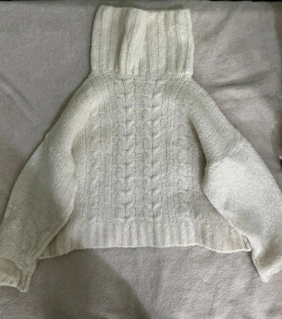 Sweater blanco de lana tejido con trenzas y cuello alto. Un básico súper canchero para el frío, ideal para combinar con todo.