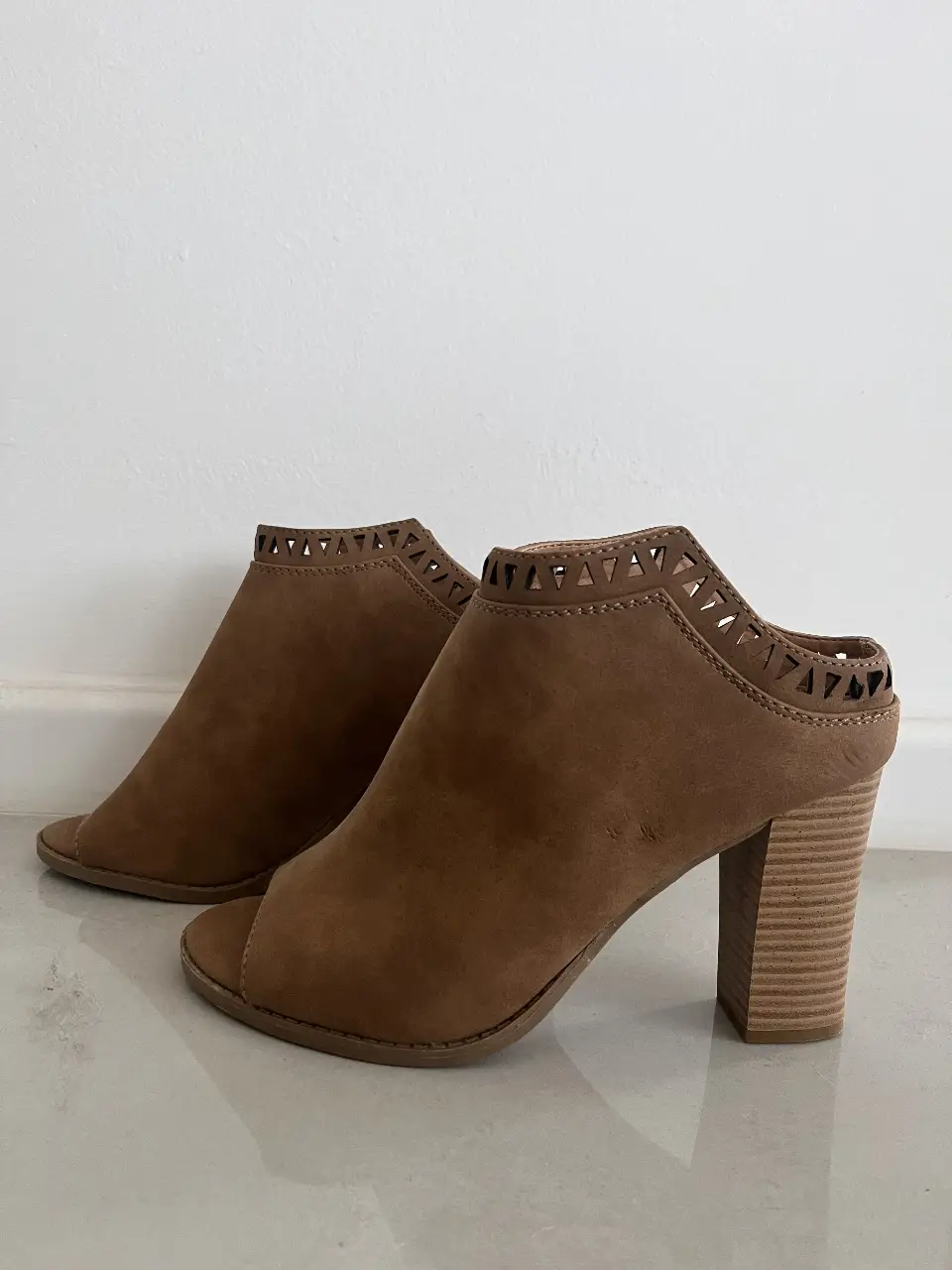 Tacos abiertos de gamuza marrón, con detalles calados en el borde superior y taco ancho. Ideales para un look elegante y cómodo.