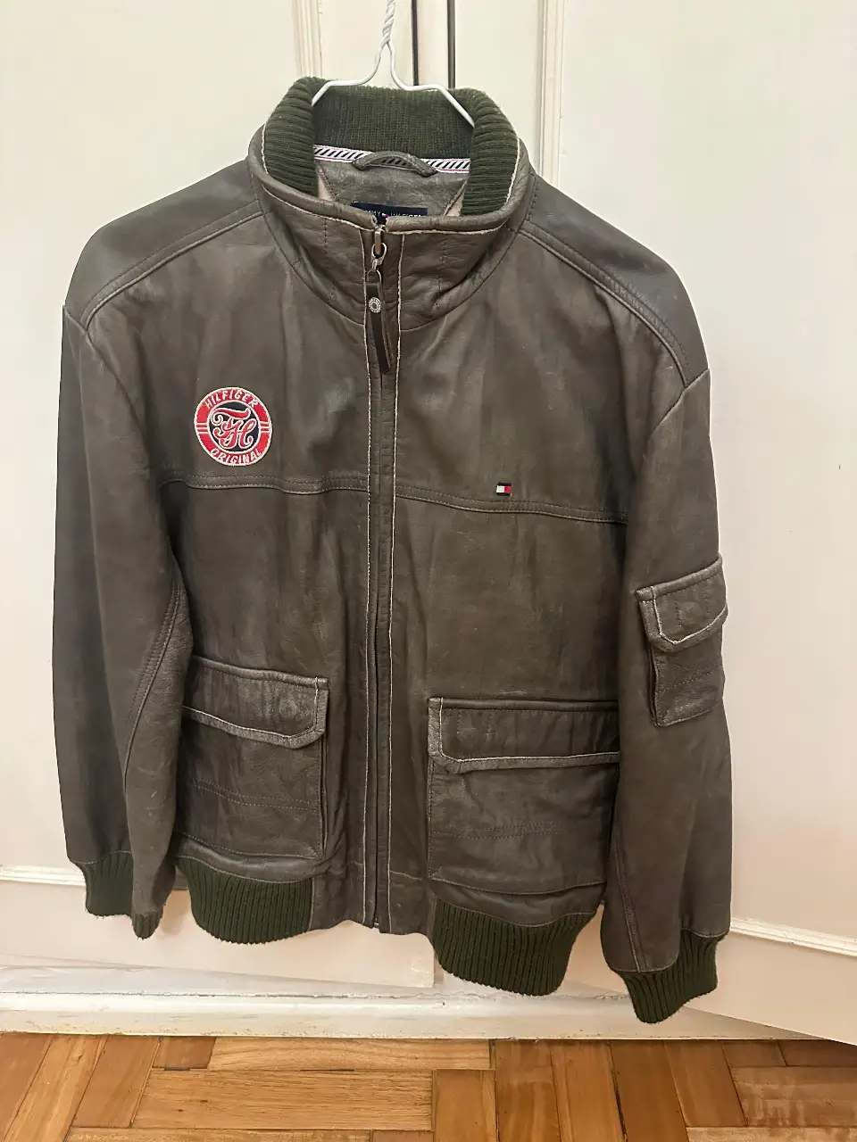 Campera de cuero Tommy Hilfiger, estilo biker, con detalles de parches y ribetes verdes. Talle 14.