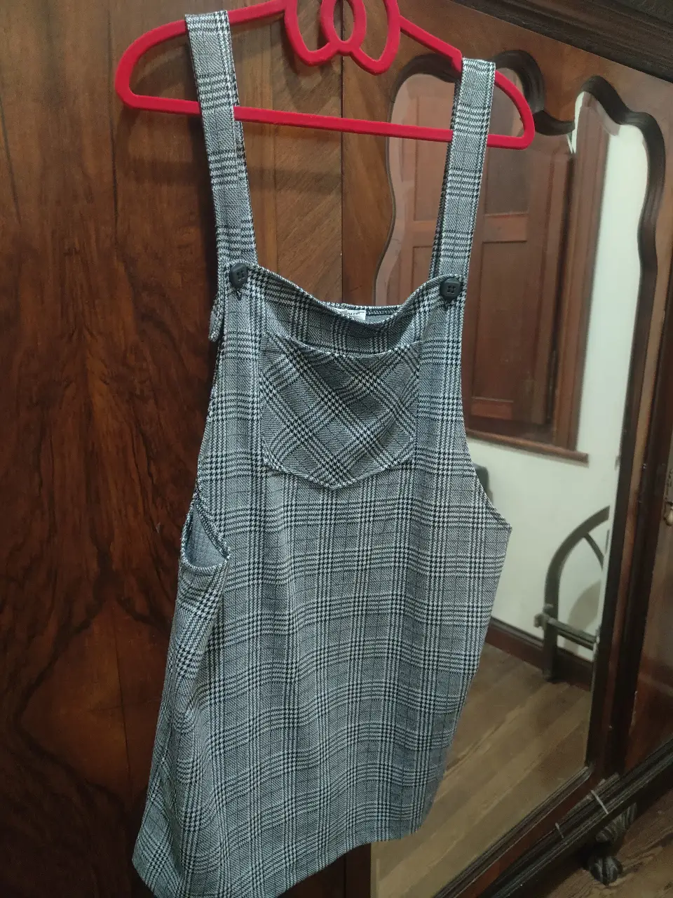 Vestido jardinero de mujer, con estampado a cuadros en tonos grises y blancos. Tiene un bolsillo en el pecho y bolsillos laterales. Talle L.