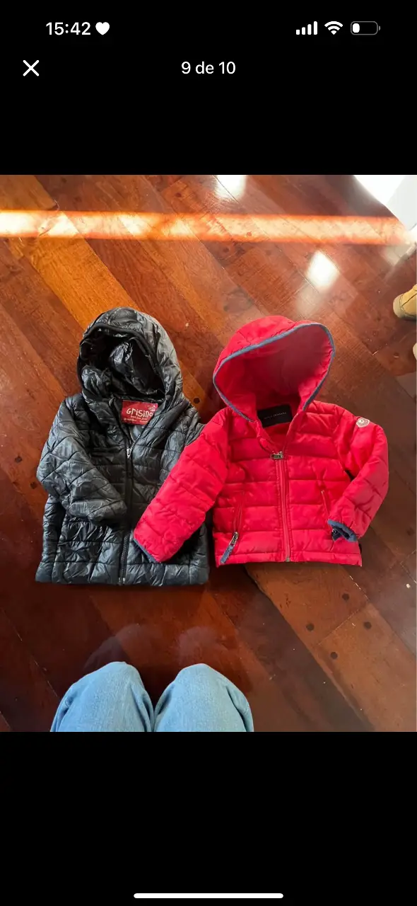 Camperas de pluma para niños, una negra y una roja, ideales para el invierno. Ambas con capucha.