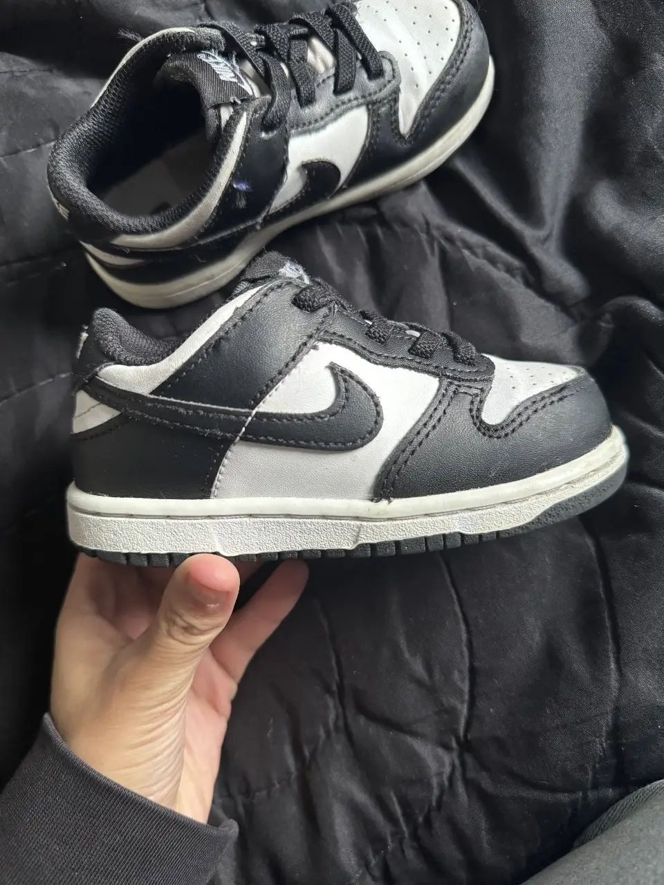 Zapatillas Nike Dunk Low para niños, en blanco y negro. Diseño clásico y cómodo para uso diario.