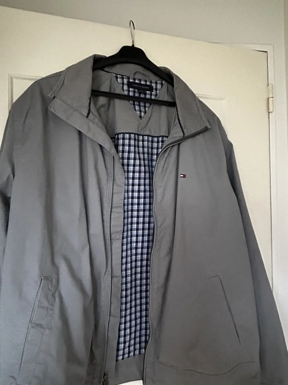 Campera Tommy Hilfiger gris para hombre, con forro a cuadros. Ideal para un look casual y cómodo.