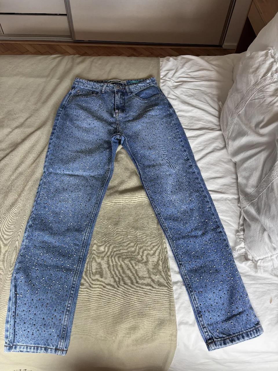 Jeans tiro alto con brillos, ideales para un look canchero y moderno. Perfectos para salir o para darle un toque especial a tu outfit diario.