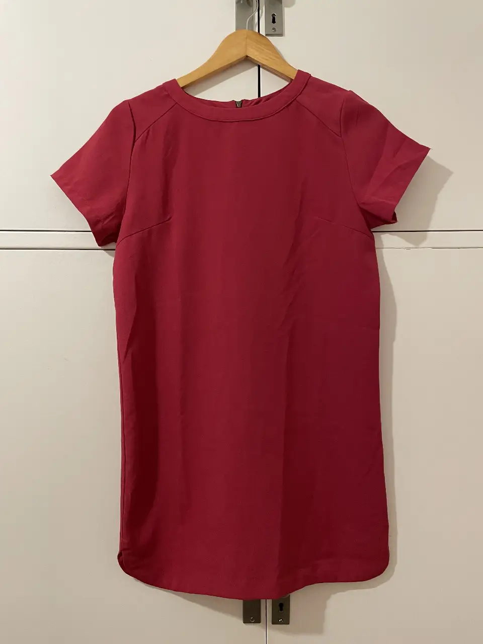 Vestido midi de color fucsia, con mangas cortas y cierre en la espalda. Ideal para un look elegante y versátil.