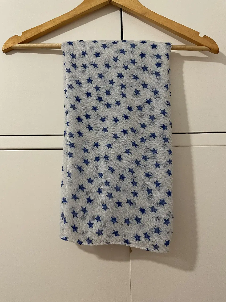 Pañuelo de tela fina con estampado de estrellas azules sobre fondo blanco. Ideal para complementar cualquier look.