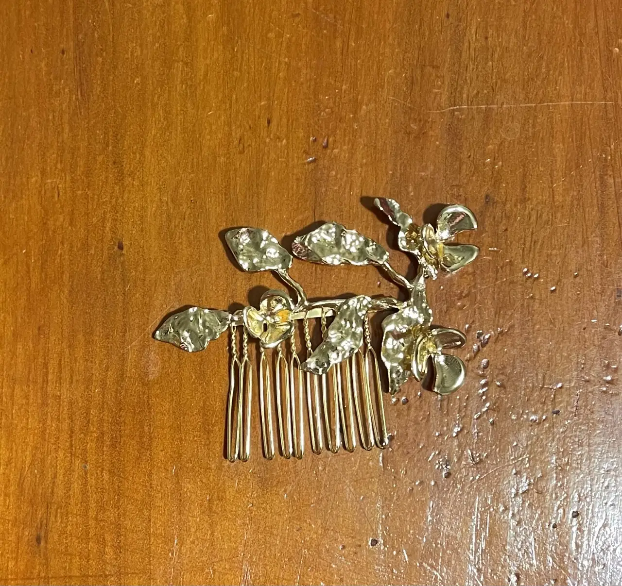 Broche dorado para el pelo con diseño floral. Ideal para darle un toque elegante a cualquier peinado.