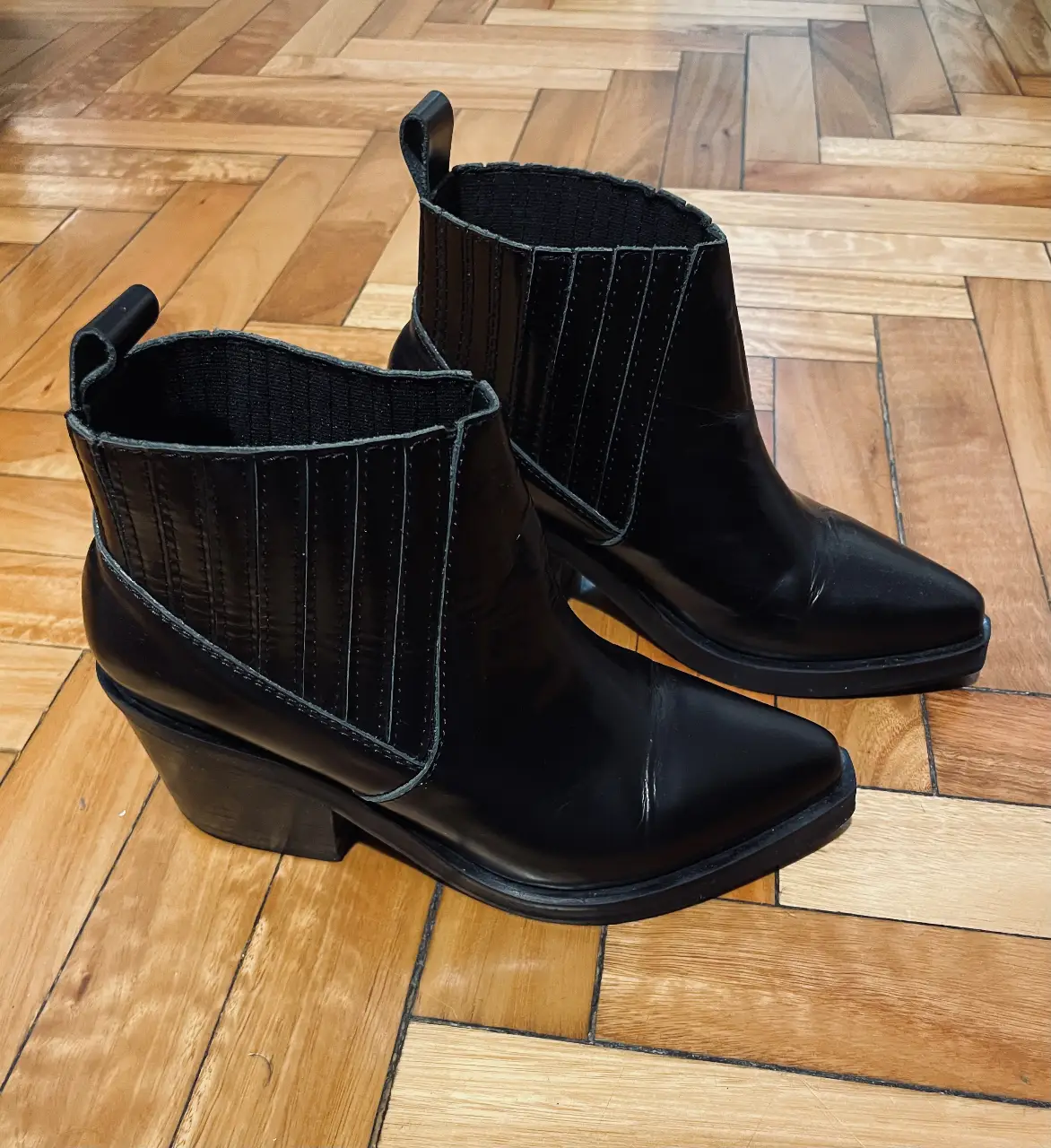Botines negros de cuero sintético con detalle de costuras y elástico en el lateral. Talle 35, marca Mishka.