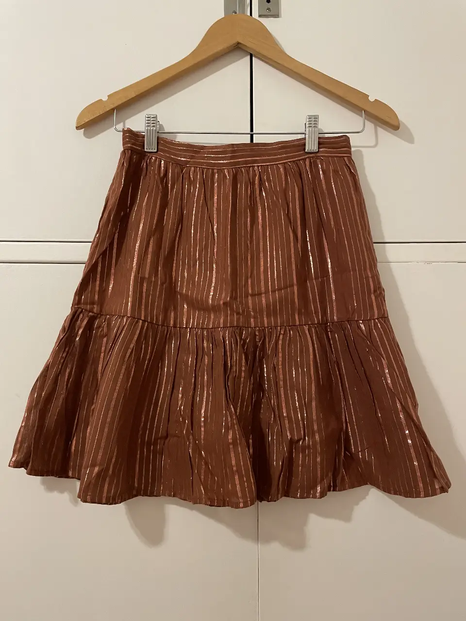 Pollera larga marrón con detalles dorados, ideal para un look elegante y sofisticado.