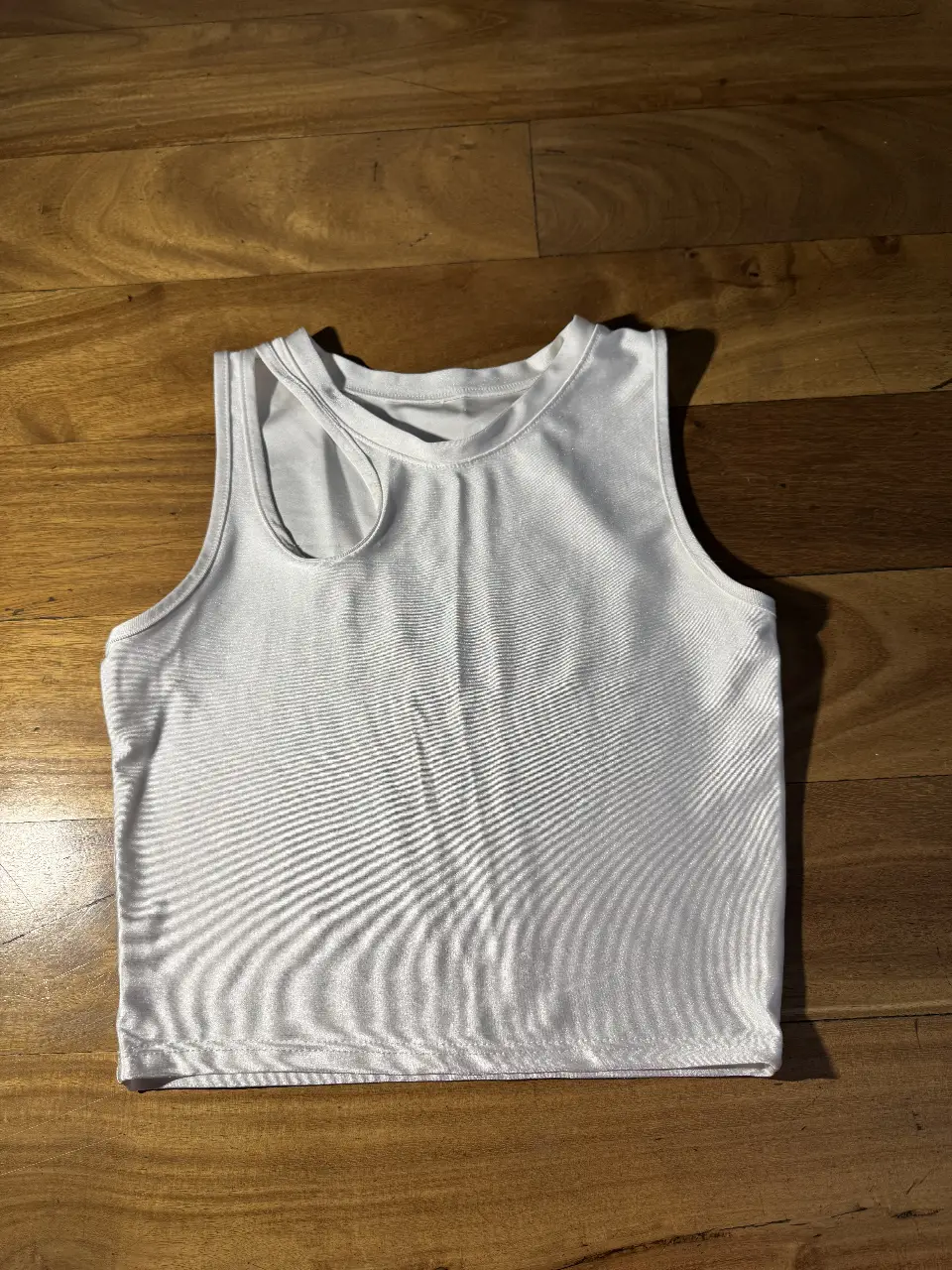 Top blanco con diseño asimétrico en el hombro. Ideal para un look moderno y fresco.