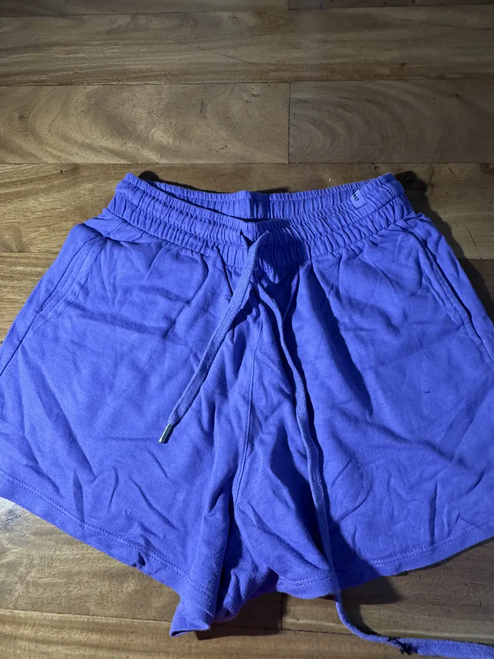 Short de mujer, color violeta, con cintura elastizada y cordón para ajustar. Ideal para actividades físicas o para un look casual y cómodo.