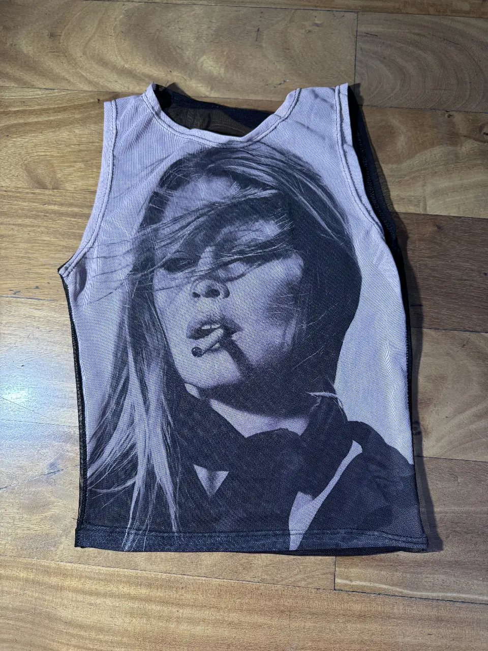 Musculosa de red con estampado de rostro en blanco y negro. Ideal para un look audaz y moderno, perfecta para festivales o salidas nocturnas.