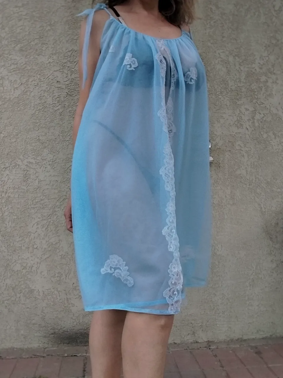 divino y seductor Camisón súper delicada y romántica,en un tono celeste pastel. Confeccionada en tela de voile transparente doble, tiene detalles de encaje blanco en el escote y en el ruedo, que le dan un toque súper femenino y coqueto. Los breteles son finitos y se anudan en los hombros, permitiendo ajustar el calce a tu gusto. Ideal para sentirse hermosa y cómoda en casa.