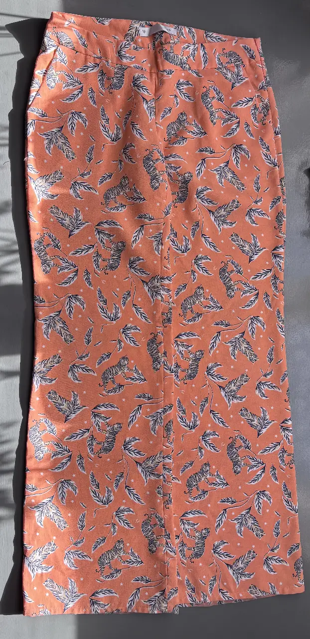 Pollera larga con estampado de tigres y hojas en tonos naranja y blanco. Ideal para un look fresco y con onda.