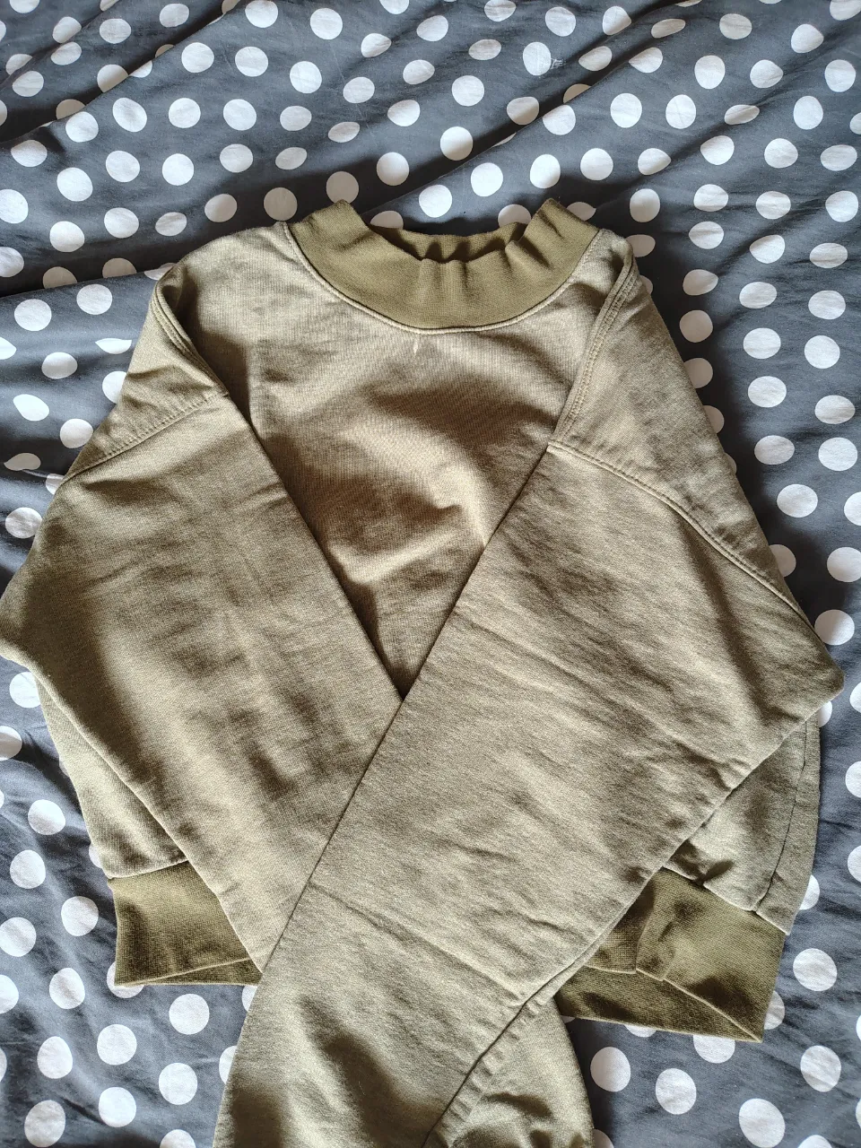 Buzo de manga larga con cuello redondo y puños anchos. Posee una etiqueta interior con la marca "BRAKE UP". Tiene una mancha blanca en la parte superior 