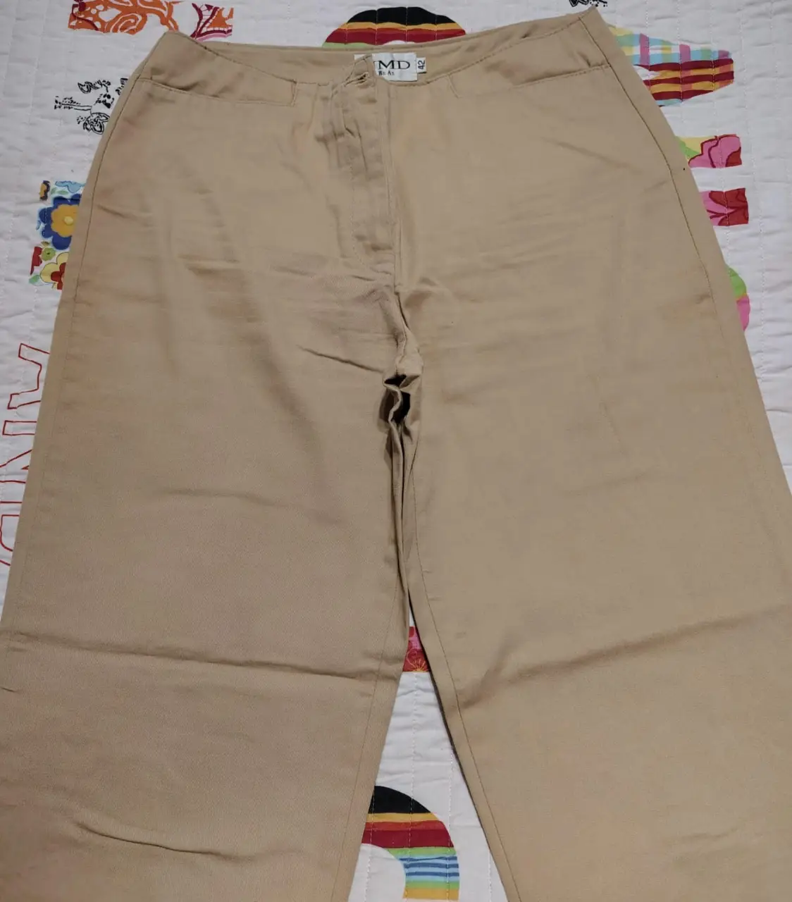 Pantalón sastrero color khaki, con corte recto y bolsillos traseros con botones. Talle 42.