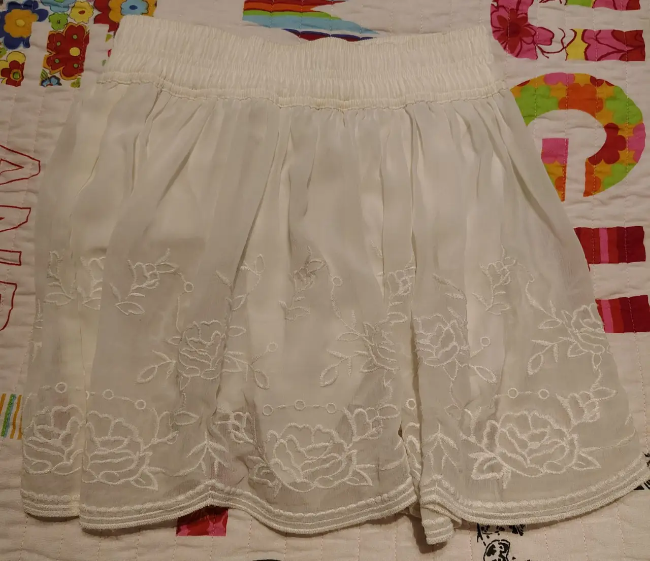Pollera larga de mujer, color blanco, con bordado floral en el borde inferior. Talle XS, de la marca Forever 21. Ideal para un look casual y fresco.