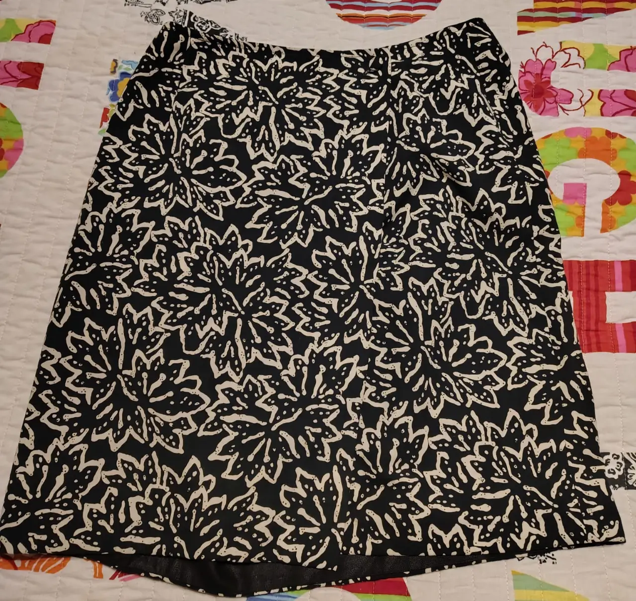 Pollera negra con estampado floral blanco de la marca Yagmour Express. Talle 42. Ideal para un look elegante y sofisticado.