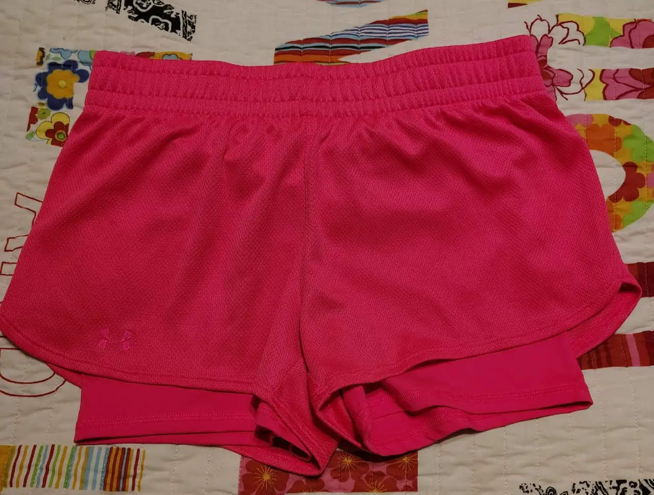 Short deportivo rosa de mujer, semi-ajustado, con doble capa y logo de la marca. Ideal para actividades deportivas.