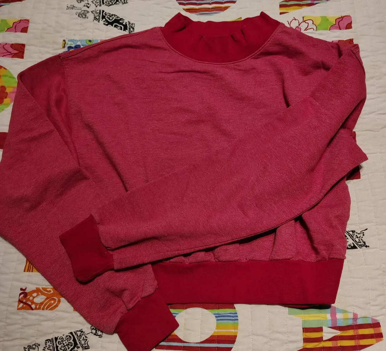 Buzo de cuello redondo rojo, con puños y cuello en contraste, cortito. Ideal para un look casual y cómodo.