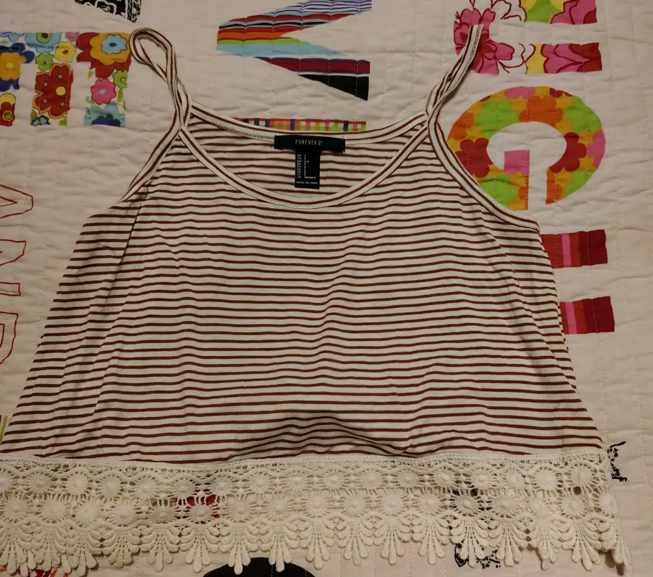 Top de mujer a rayas marrones y blancas con detalle de encaje en el bajo. Ideal para un look casual y fresco.