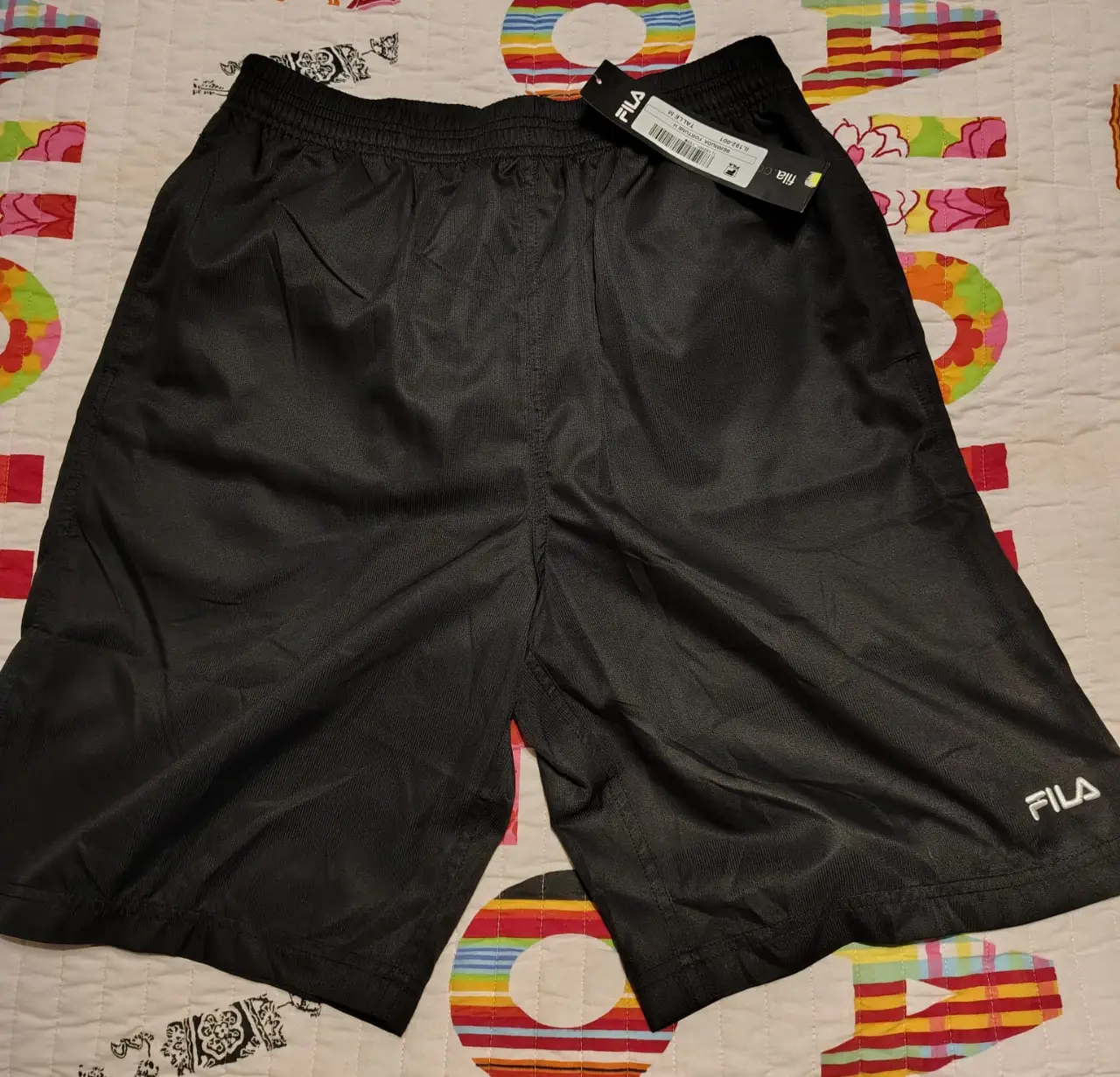 Short deportivo negro de hombre, marca Fila. Confeccionado en poliéster, ideal para actividades físicas. Talle M, con etiqueta