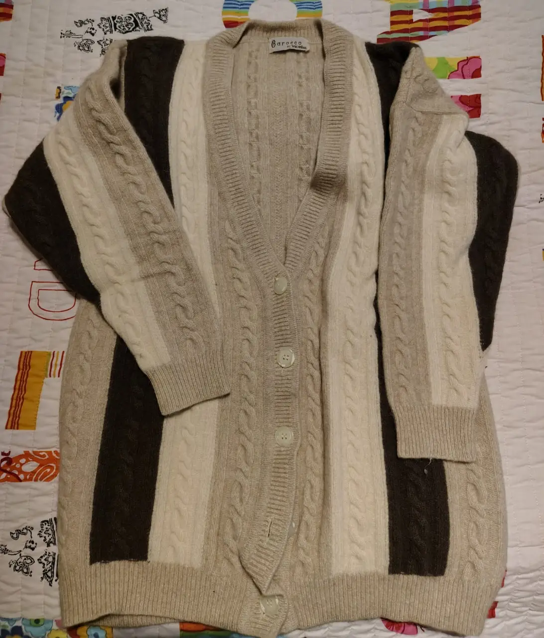 Cardigan largo de punto con diseño a rayas en tonos marrones, beige y blanco. Ideal para un look casual y abrigado.