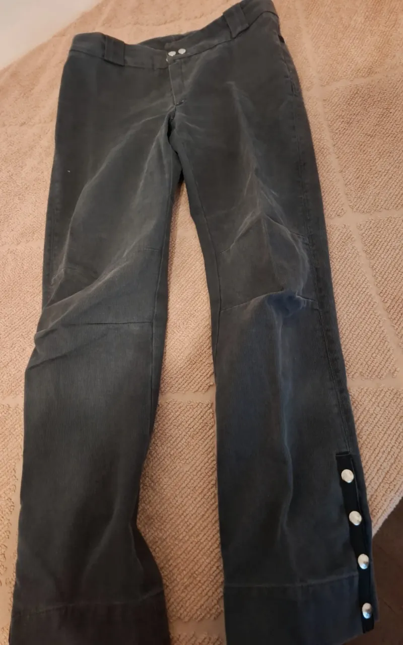 Pantalón de corderoy  gris oscuro, corte recto, con detalles de botones en los laterales de la bota