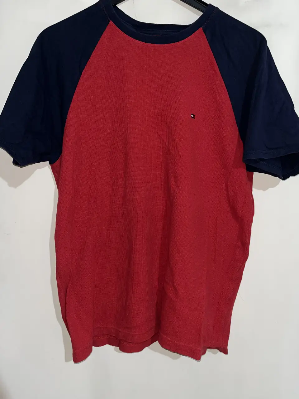 Remera Tommy Hilfiger de hombre, manga corta con diseño raglán en color rojo y mangas azul marino. Cuello redondo. 