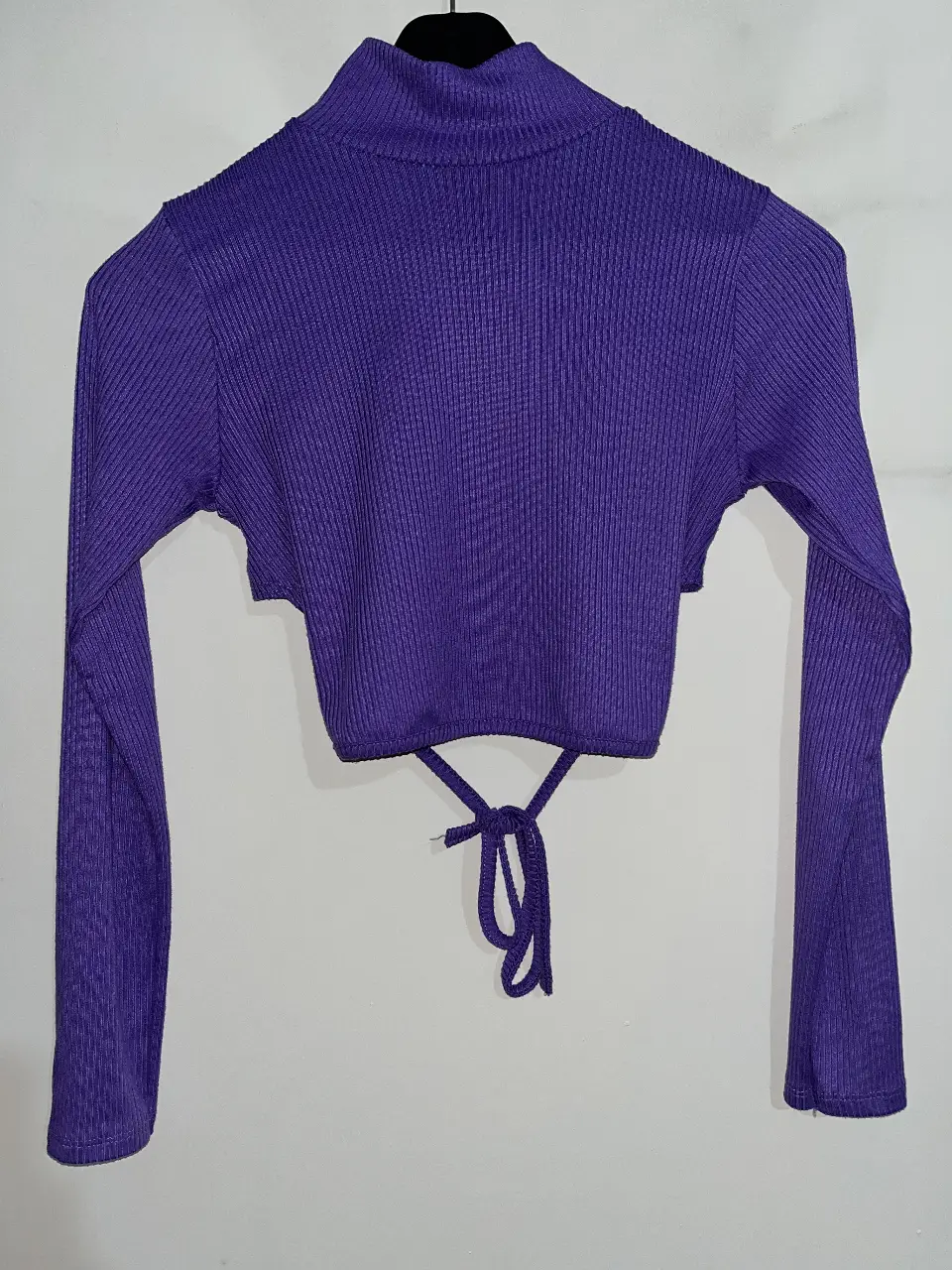Top manga larga violeta de cuello alto y de Morley. Con abertura en la espalda y lazos para atar. Talle único. 
