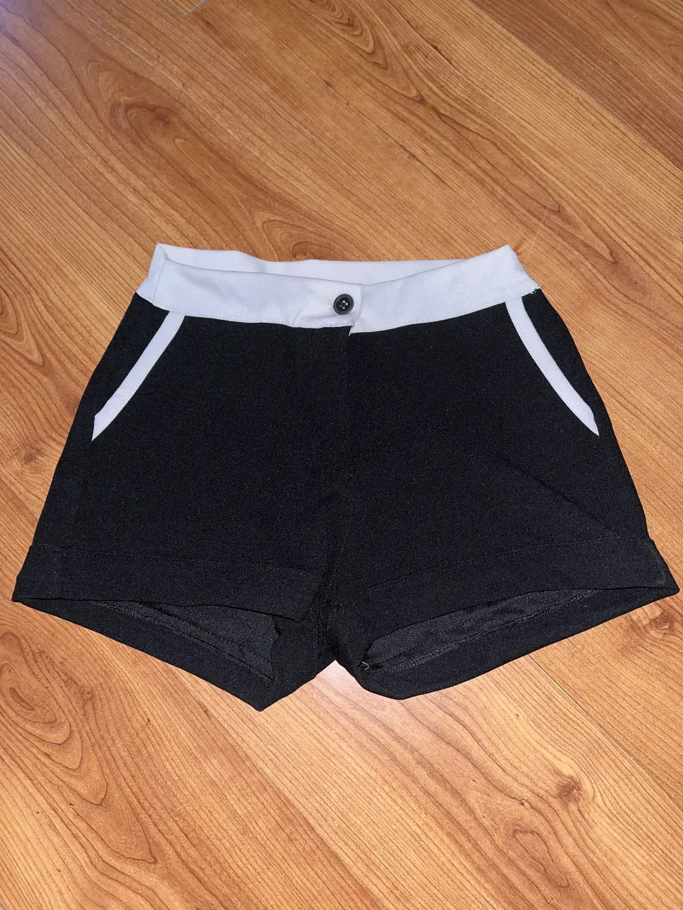 Short bicolor en negro con detalles blancos en cintura y bolsillos. Corte recto, cómodo y moderno. Tela liviana y suave al tacto, no se arruga fácil. Tiro medio/bajo. Talle 38/40 – talle S o M.