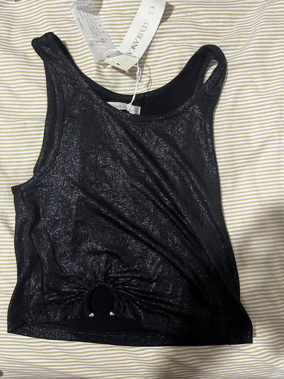 Musculosa negra con brillos y nudo delantero.