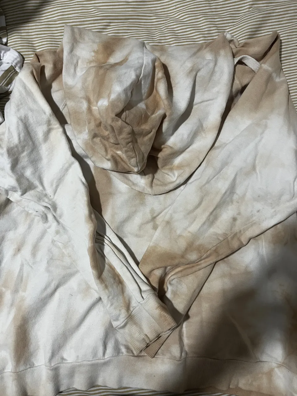 Buzo con capucha y estampa tie-dye en tonos crudo y marrón.