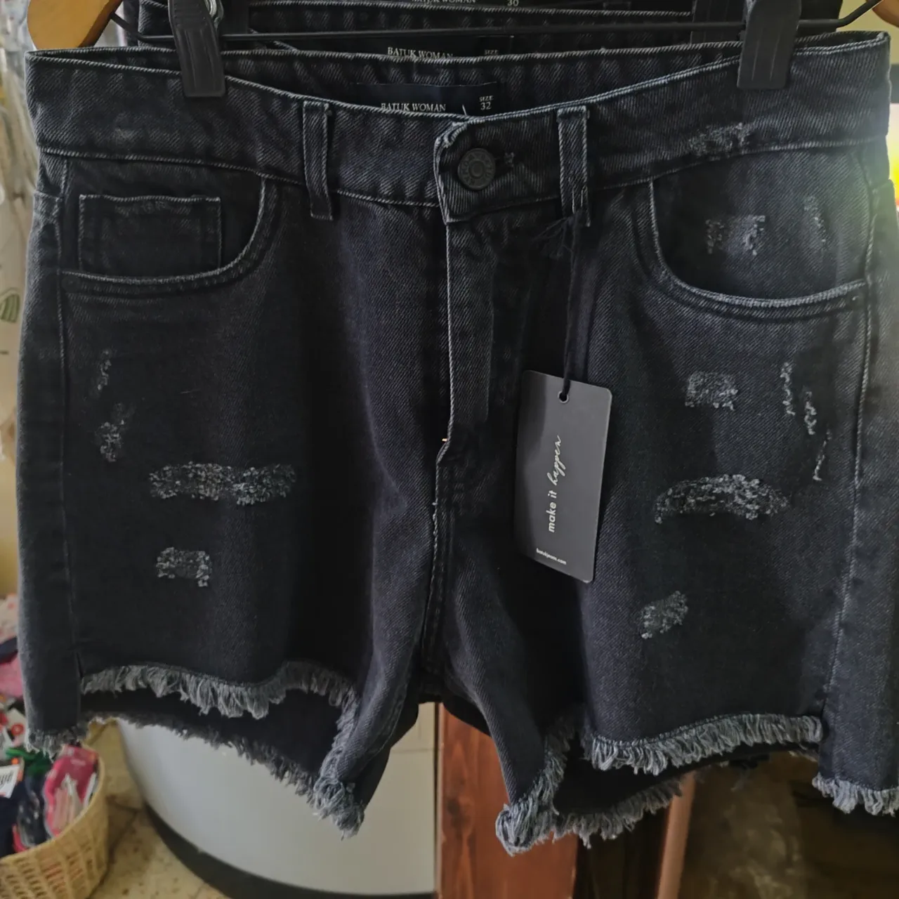 Shorts de jean negros con roturas y terminación desflecada.