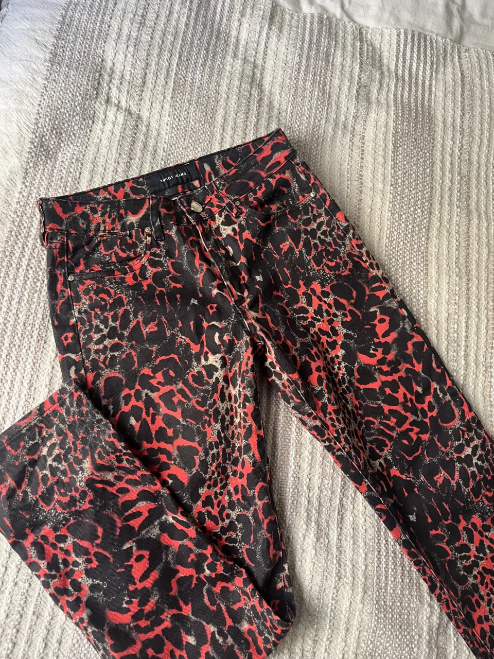 Jeans TUCCI con estampa animal print en rojo y 
negro. Tiro medio/bajo rectos. Poco uso