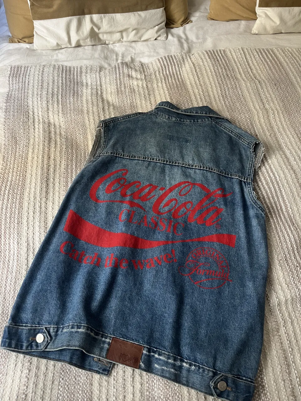 Chaleco 47 Street de jean azul con roturas y estampa "Coca-Cola" en la espalda.