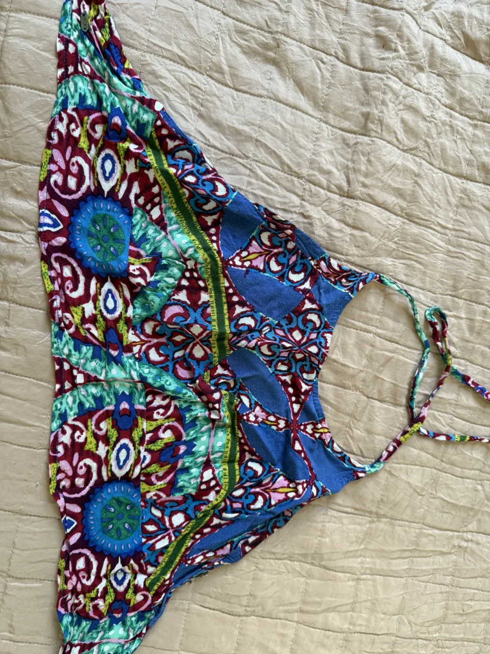 Top estampado súper colorido, ideal para el verano. Tiene un diseño vibrante  y tiras para atar en la espalda. Perfecto para un look playero o casual.