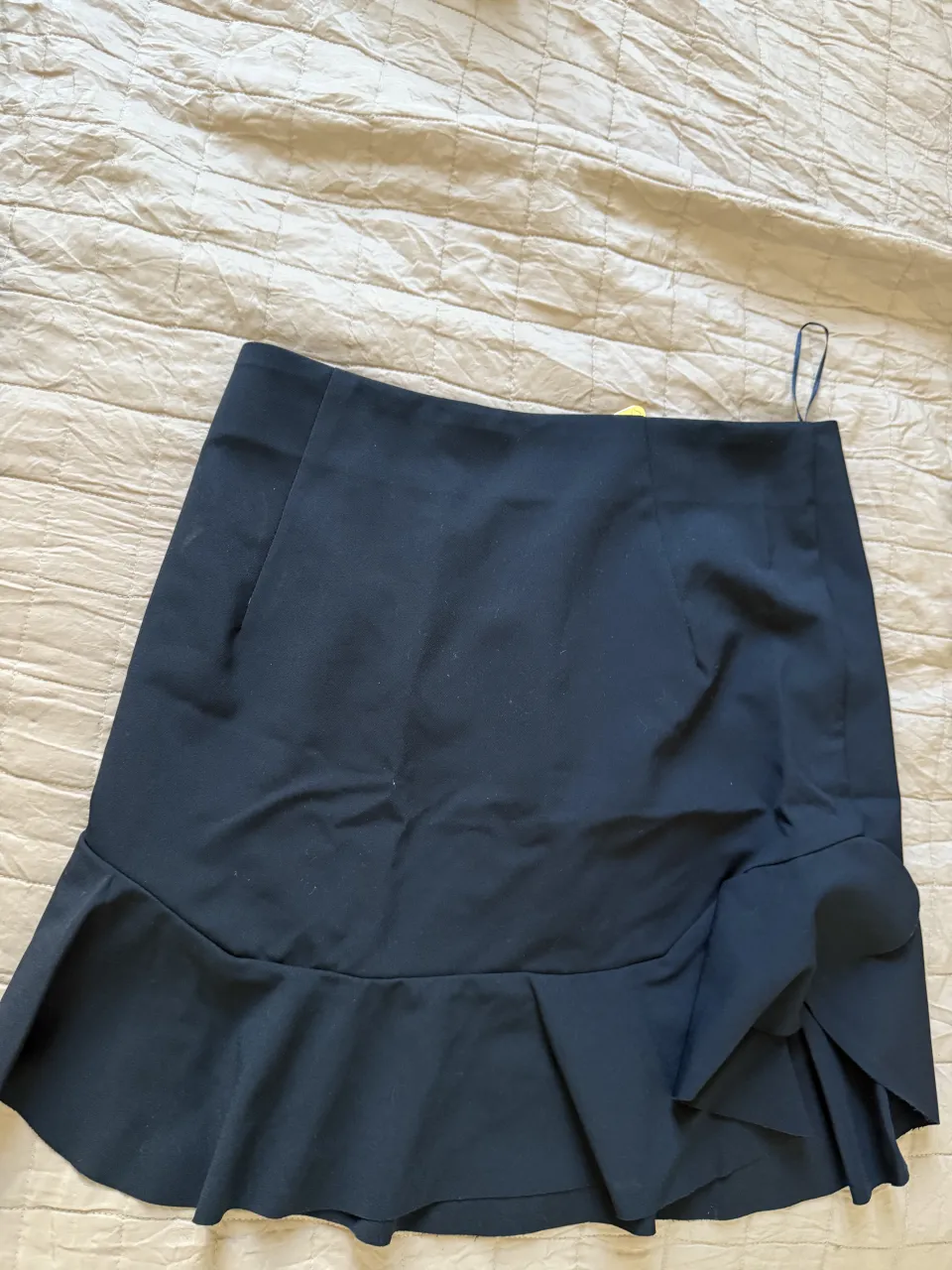 Pollera negra corta con volados y cierre metálico dorado. Ideal para looks de fiesta o salida.