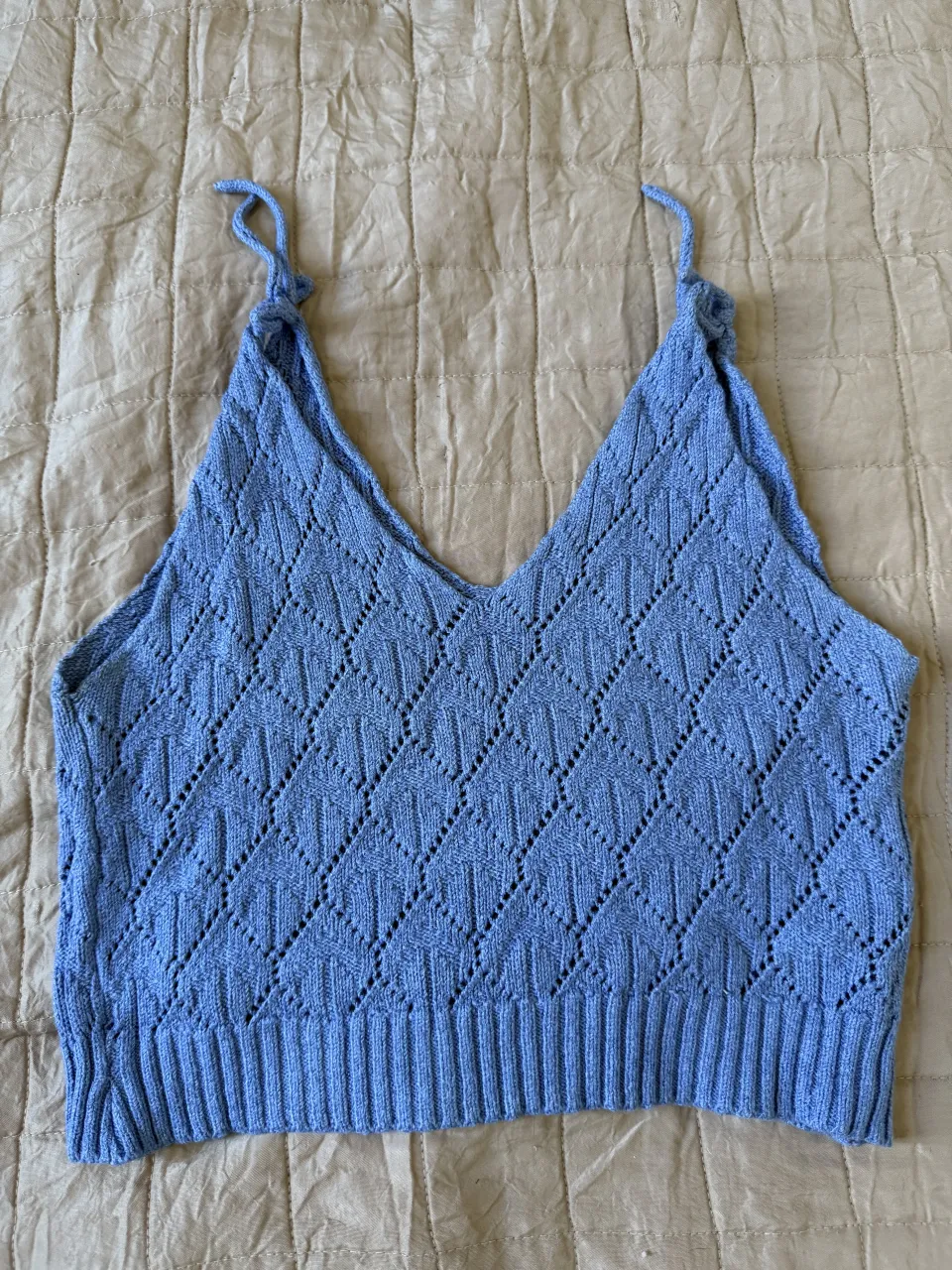 Top tejido de breteles finitos con detalle de rombos calados. Ideal para un look canchero y fresco.