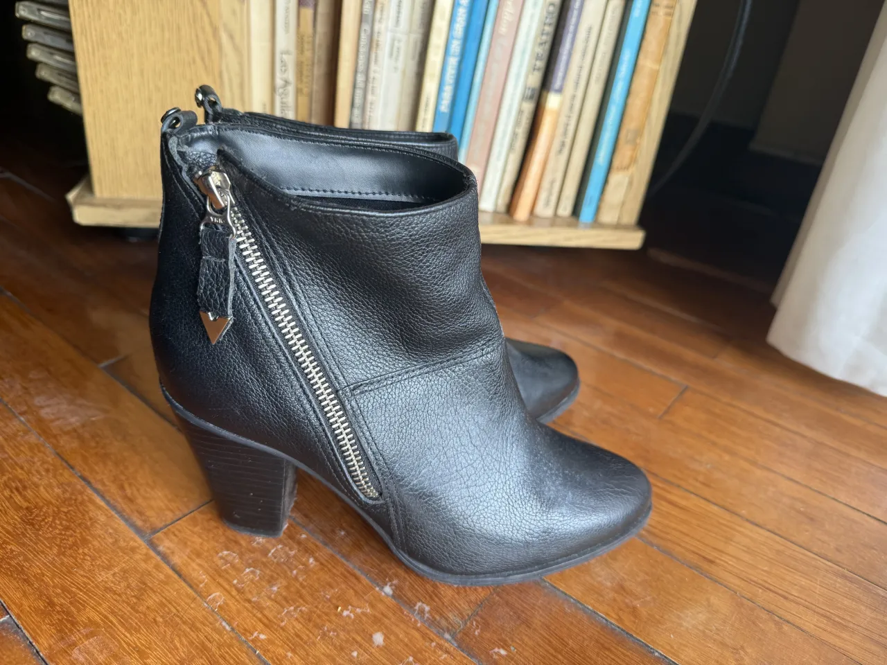 Botitas negras de cuero con cierre lateral plateado y taco grueso.