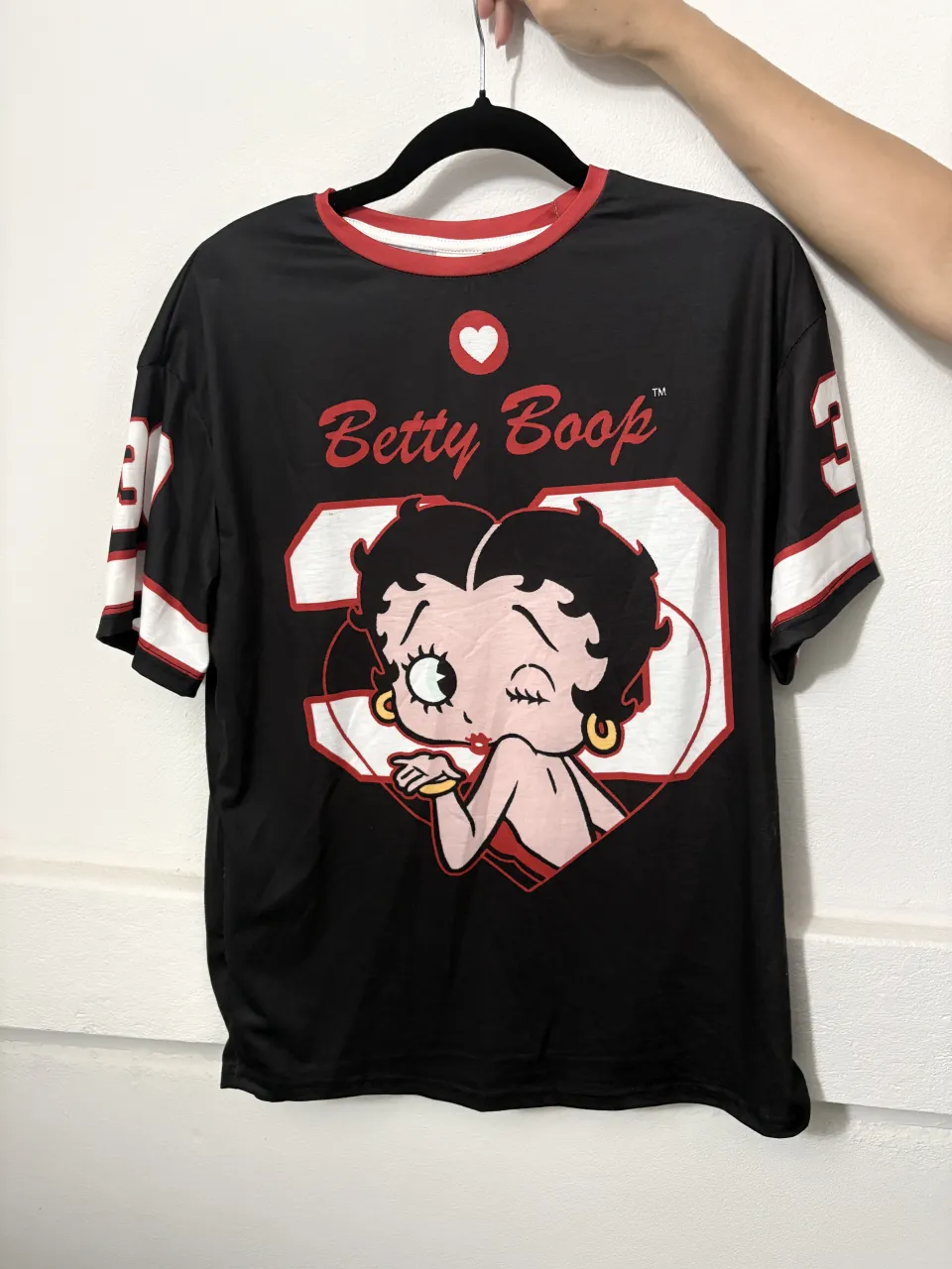 Remera negra de manga corta con cuello redondo y detalles en rojo. Estampado frontal de Betty Boop.

Talle S y M 