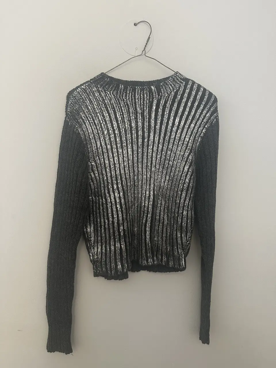 Sweater de mujer con diseño de rayas plateadas y mangas grises. Ideal para un look moderno y elegante. Medidas: 44 espalda y 50 largo