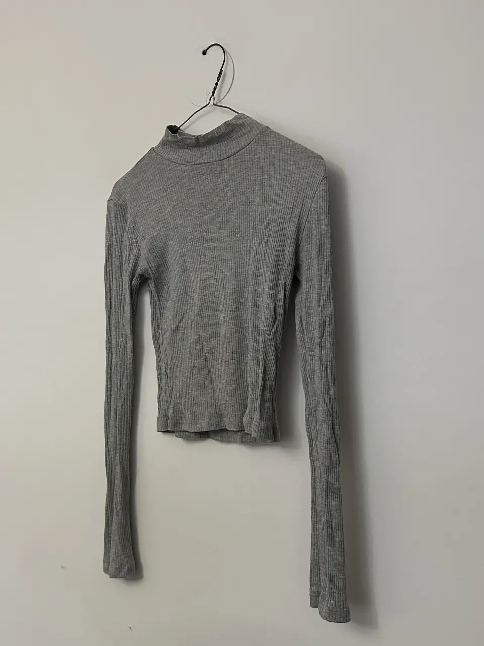 Remera de manga larga gris, con cuello alto y tejido acanalado. Ideal para un look casual y versátil. medidas: largo 44 cm - espalda 40 cm - sisa a sisa 37 cm - largo mangas 60 cm 