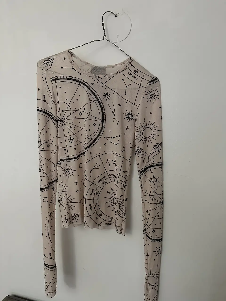 Remera manga larga de tela transparente con estampado de constelaciones. Ideal para un look casual y moderno. Medidas: espalda sin estirar 34 cm - sisa a sisa 38 cm - largo 56 cm y largo mangas 77 cm 