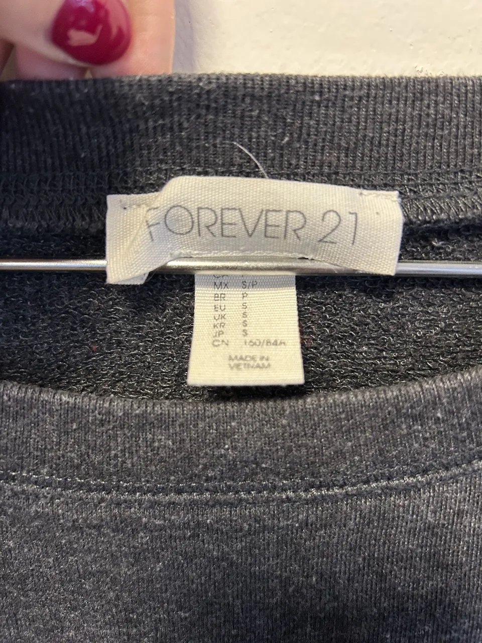 Buzo de cuello redondo de la marca Forever 21, color gris oscuro. Ideal para un look casual y cómodo.