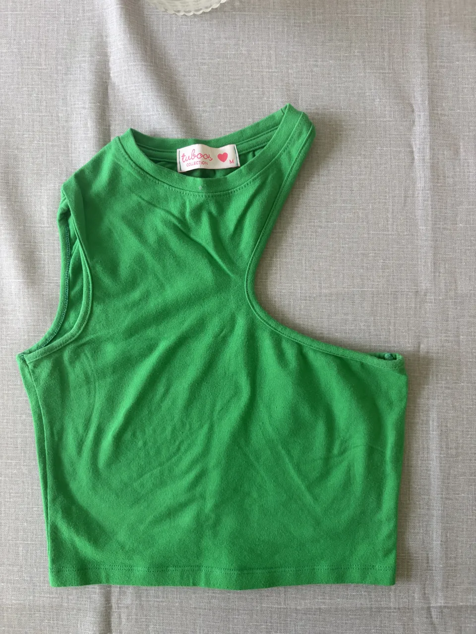 Top verde vibrante, ideal para un look canchero y moderno. Su diseño único lo hace perfecto para destacar en cualquier salida.
