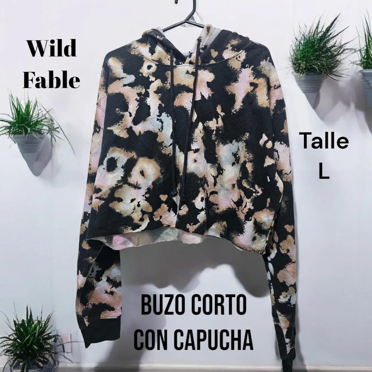 Buzo corto con capucha, estampado tipo tie-dye en tonos negros, beige y rosados. Ideal para un look casual y moderno.
