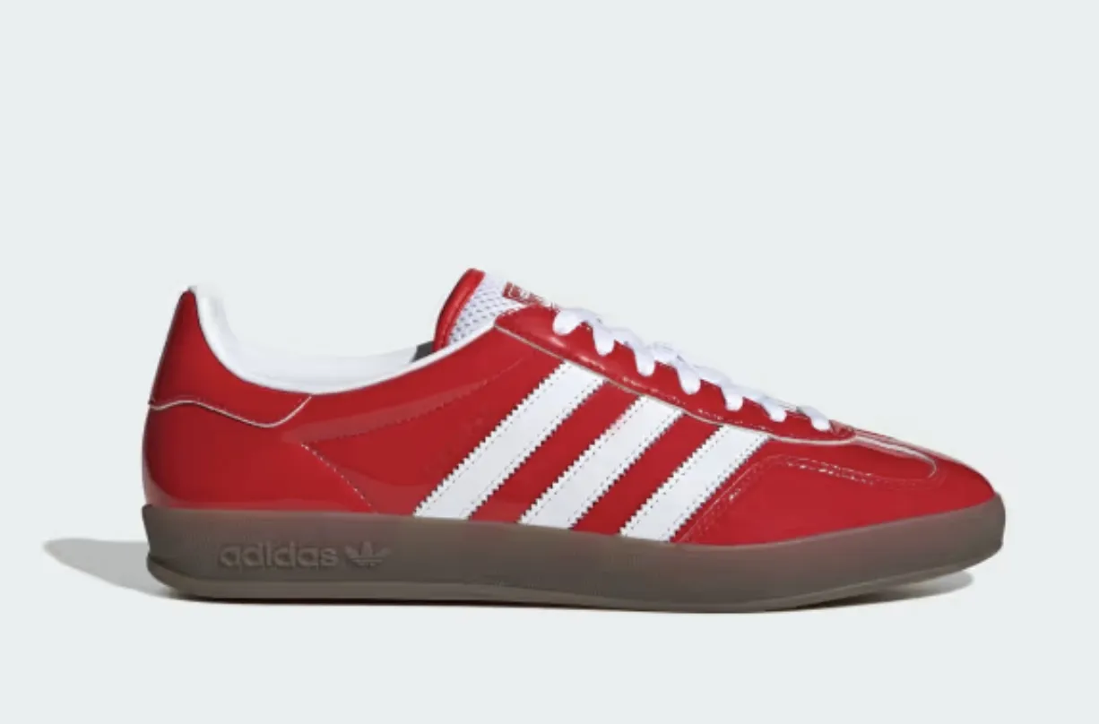 Zapatillas Adidas rojas con detalles blancos y suela marrón. Diseño clásico y moderno, ideales para un look casual y urbano. Perfectas para combinar con jeans o pantalones deportivos.