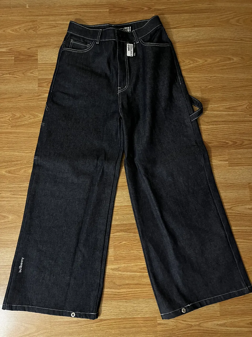 Pantalón de jean Bullbenny, corte ancho, estilo skater, con detalles de costuras blancas y logo de los Yankees en el bolsillo trasero. Sin uso. Talle 42 (002)
