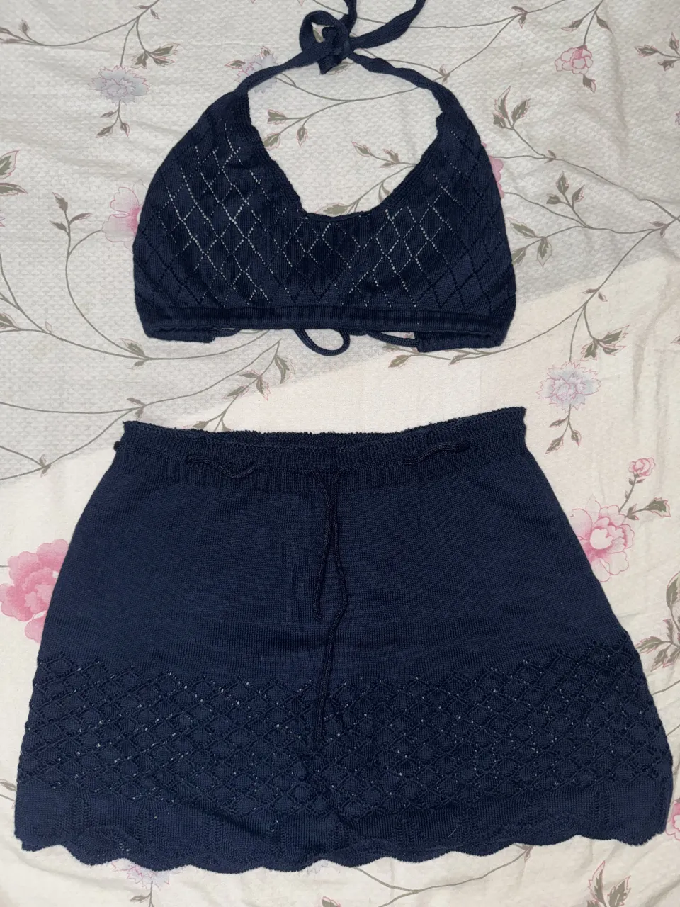 Conjunto de dos piezas tejido, ideal para el verano. Incluye un top tipo corpiño con breteles y una pollera corta con detalles de crochet.